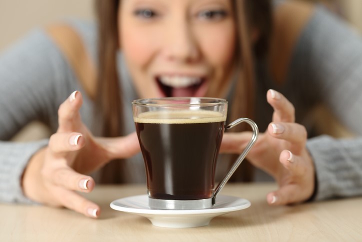 Woman grabbing cup of coffee
