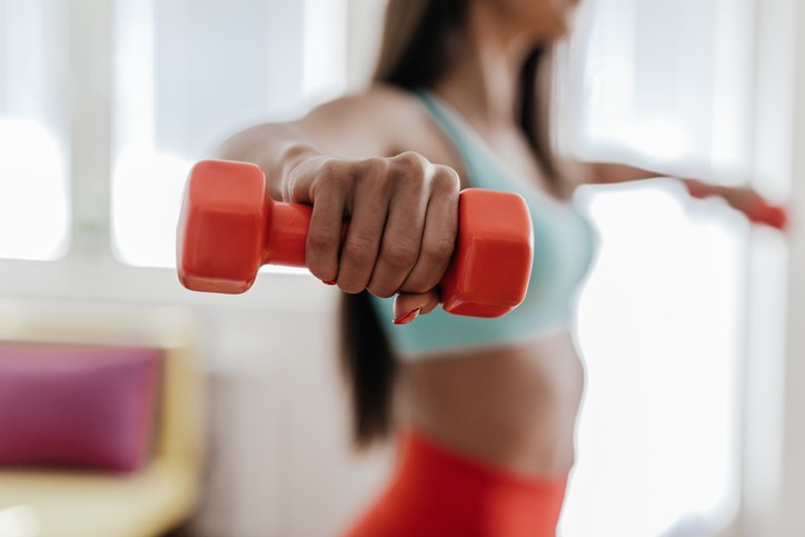 Woman with dumbbells in her hand.