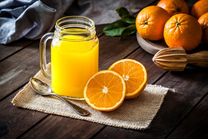 orange juice inside mason jar with oranges