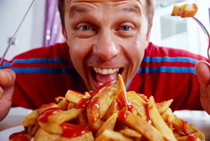 man with plate of fries with ketchup